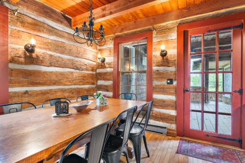 a dining room with a table and chairs and a red door at Log Cabin on Kangaroo Lake by Simple Life Rentals in Baileys Harbor