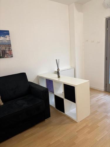 a living room with a black couch and a white cabinet at In centro da Ale in Seregno