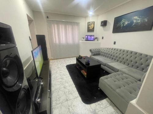 a living room with a couch and a flat screen tv at Casa San Rafael (Centro) in San Rafael