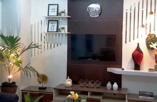 a living room with a tv and a table with vases at Tony's Place - Second Level in Santa Maria