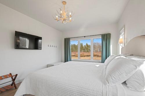 a white bedroom with a bed and a window at Orchard View Retreat by Simple Life Rentals in Egg Harbor