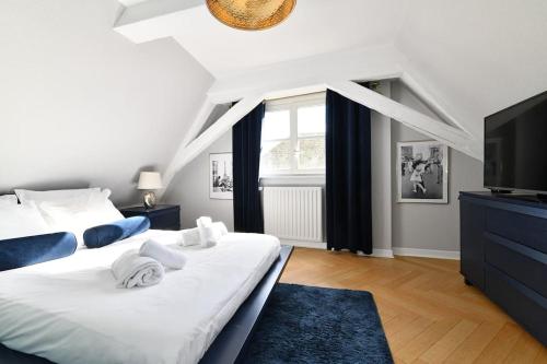 une chambre avec un grand lit blanc et une télévision dans l'établissement Envole moi vers la lune - 4 guests - 2 BR - City, à Colmar