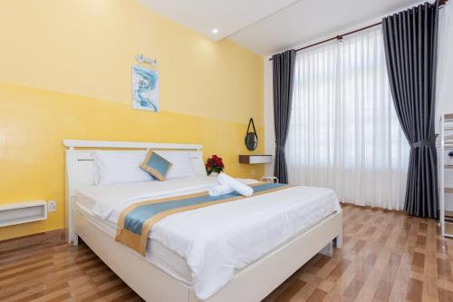 a bedroom with a large bed with yellow walls at Minh Phước Villa 12 Kim Ngân in Vung Tau