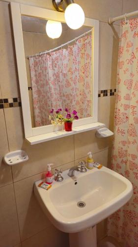 a bathroom with a sink and a mirror and a window at Departamentos Atardecer Serrano in Arroyo de Los Patos