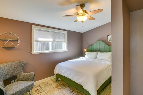 a bedroom with a bed with a ceiling fan and a chair at 1 Mi to City Plaza Family-Friendly Chico Home in Chico