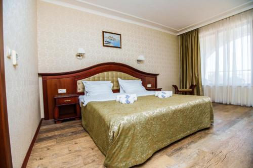 a hotel room with a large bed and a window at Aqua View SPA Boutique Hotel in Golden Sands