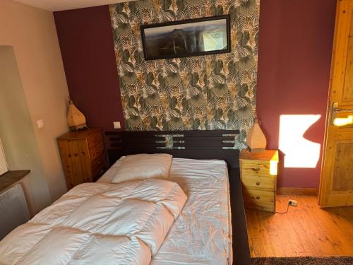 a bedroom with a bed and a tv on a wall at Villa Boston in La Bourboule