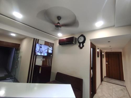 a room with a ceiling fan and a clock on the wall at Hotel Earth Inn, Subhash Bridge, RTO Circle, Ahmedabad in Ahmedabad