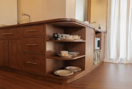 a wooden cabinet with plates and dishes in it at Gimnyeong Musgo in Jeju