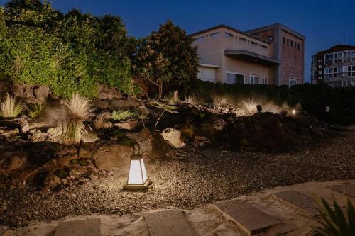 a light in a garden in front of a building at Gimnyeong Musgo in Jeju