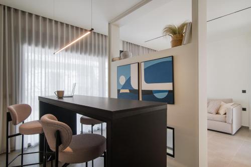 a dining room with a black table and chairs at Kleopatra Homes in Messini