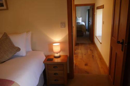 a bedroom with a bed and a lamp on a night stand at Cherry Trees - 2 bedrooms -Pets Ok - woodburner in Hereford