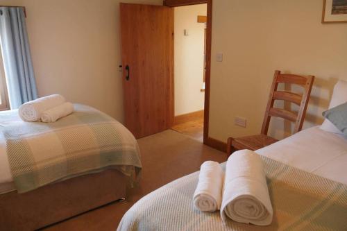 a room with two beds with towels on them at Cherry Trees - 2 bedrooms -Pets Ok - woodburner in Hereford