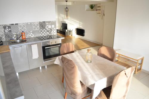 une cuisine avec une table et des chaises dans une cuisine dans l'établissement Bel appartement type maison, à Rosny-sous-Bois