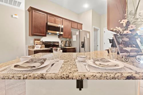 a kitchen with a table with plates and napkins at Petfriendlymid-term Stays2king Beds&desk in Lake Charles