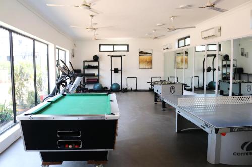 a room with a pool table and ping pong tables at Afrokan Hotel in Accra