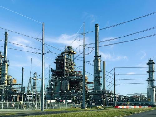 a factory with many pipes on a blue sky at Petfriendlymid-term Stays2king Beds&desk in Lake Charles