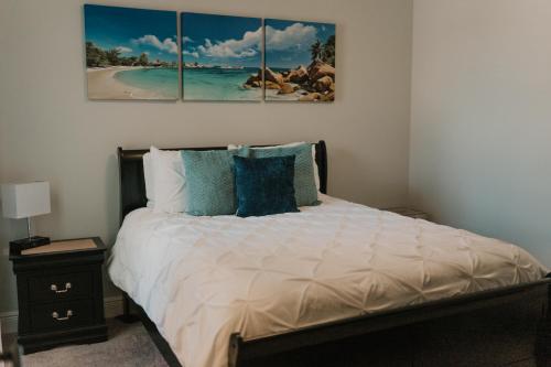 a bedroom with a bed with four paintings on the wall at Contractor Ready No Penalty Changes Fast Wi-F in Lake Charles