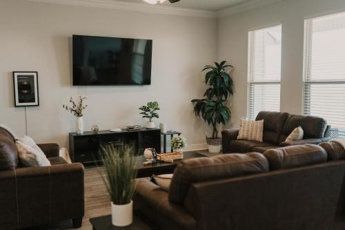 a living room with two couches and a flat screen tv at Contractor Ready No Penalty Changes Fast Wi-f in Lake Charles