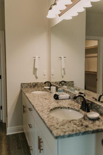 a bathroom with two sinks and a large mirror at Contractor Ready No Penalty Changes Fast Wi-F in Lake Charles