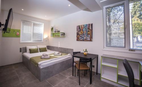 a bedroom with a bed and a table and a desk at DORM BG pet-friendly Aparthotel in Stara Zagora