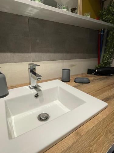 un évier blanc avec un robinet sur un comptoir dans l'établissement Le petit républicain, au Péage-de-Roussillon