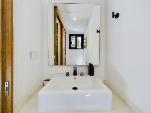 a white bathroom with a sink and a mirror at Casa Xaman in Tulum - TH 5 in Tulum