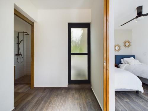 a bedroom with a bed and a shower and a window at Casa Xaman in Tulum - TH 5 in Tulum