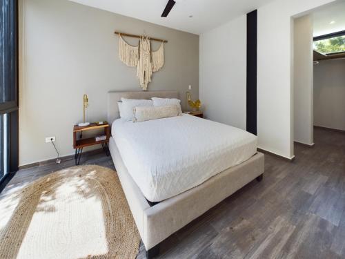 a bedroom with a large white bed and a rug at Casa Xaman in Tulum - TH 5 in Tulum