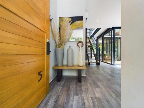 a hallway with a wooden door and vases on a table at Casa Xaman in Tulum - TH 5 in Tulum