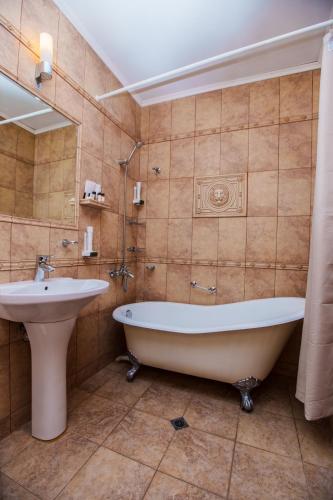 a bathroom with a tub and a sink at Aqua View SPA Boutique Hotel in Golden Sands
