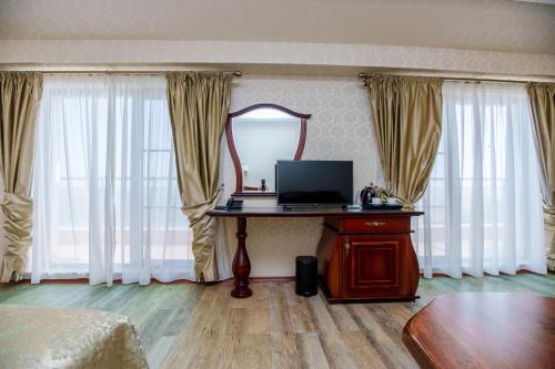 a room with a desk with a mirror and curtains at Aqua View SPA Boutique Hotel in Golden Sands