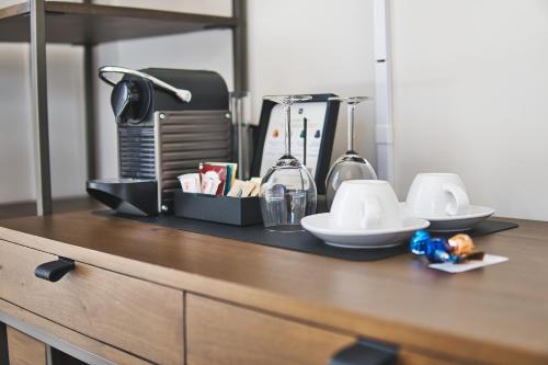 a wooden counter top with cups and dishes on it at The Windsor Hotel by Hoco Hotels Collection in Stratford