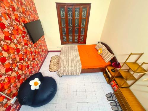 a small bedroom with an orange bed and a chair at LushStay Hanoi Train Street - Cozy in Hanoi