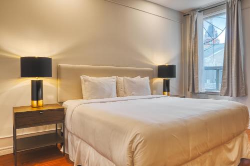 a bedroom with a large white bed with two lamps at The Windsor Hotel by Hoco Hotels Collection in Stratford