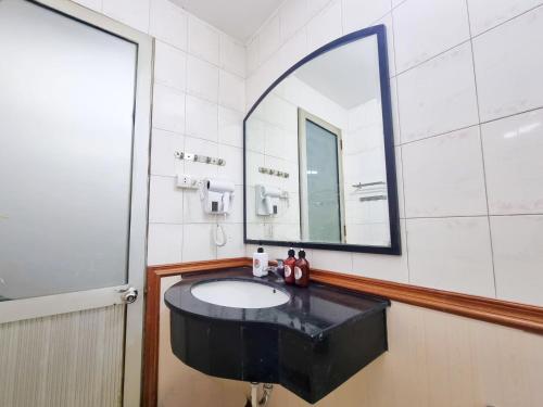 a bathroom with a black sink and a mirror at LushStay Hanoi Train Street - Cozy in Hanoi