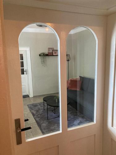 a door with a mirror in a living room at A kis parasztház in Kékesd