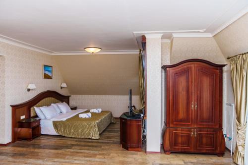 a hotel room with a bed and a wooden cabinet at Aqua View SPA Boutique Hotel in Golden Sands