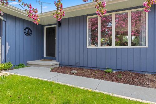 ein blaues Haus mit Fenstern und einem Hof in der Unterkunft Marina Cottage by Simple Life Rentals in Baileys Harbor