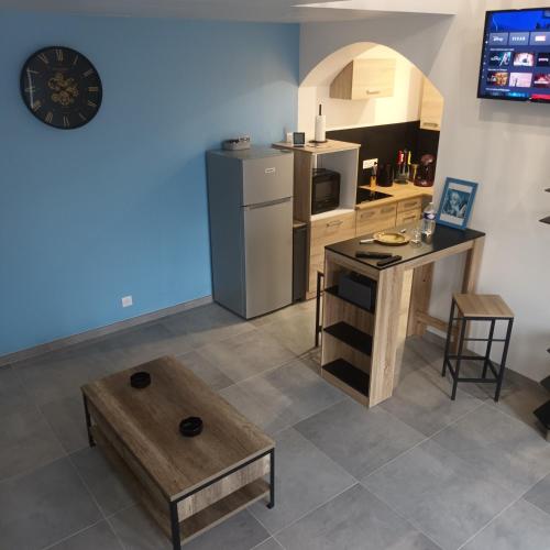 La cuisine est équipée d'une table, d'un comptoir et d'un réfrigérateur. dans l'établissement Loft entier, calme, fibre et wifi, à Saint-Quentin