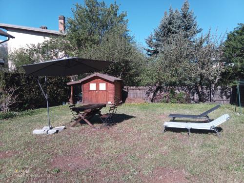 une cabane pour chiens et un parasol dans une cour dans l'établissement Villa mexiquaine, à Barcelonnette