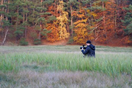 a man taking a picture in a field with a camera at Gut Groß Zecher - Ferienzimmer in Seedorf