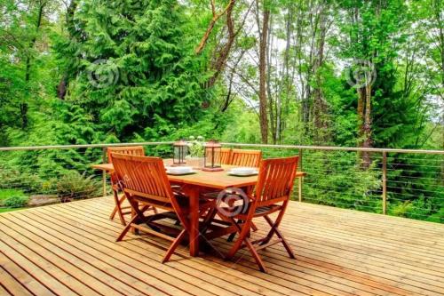 a wooden table and chairs on a wooden deck at Country in the City - Wonderful Complimentary Breakfast Delivered Daily to House in Niagara Falls