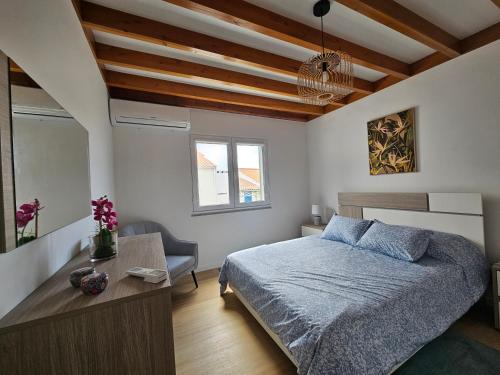a bedroom with a bed and a table and a window at Esperança House 2 in Maia