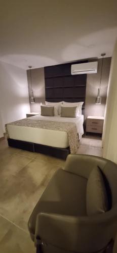 a bedroom with a bed and a chair and a couch at Hotel 45 Park in Sabaneta