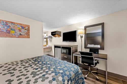 a hotel room with a bed and a desk and a computer at Econo Lodge Kingsport East in Kingsport