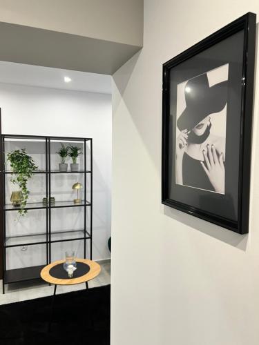 a picture of a woman in a hat on a wall at Różana City Apartaments in Kutno