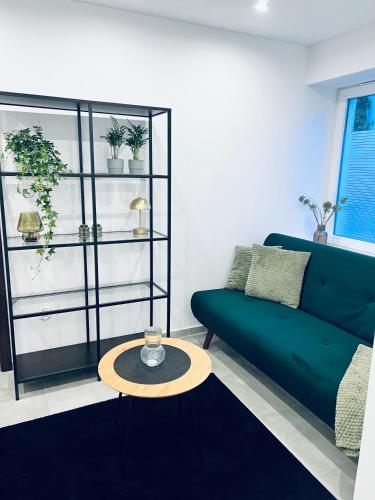 a living room with a green couch and a table at Różana City Apartaments in Kutno