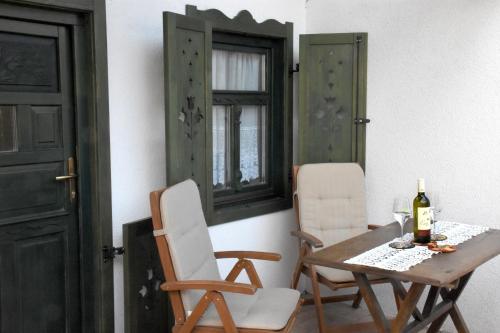 a table with two chairs and a bottle of wine at NAP-HOLD Vendégház in Pusztavám