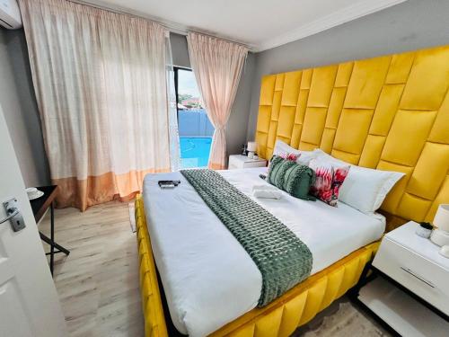 a bedroom with a large bed with a yellow headboard at The greenary guest house and restaurant in Thohoyandou